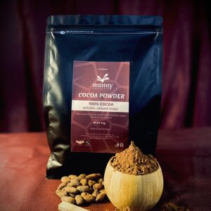 A pouch bag of Tanzania Unsweetened cocoa powder standing with cocoa beans and a wooden bowl of cocoa powder.