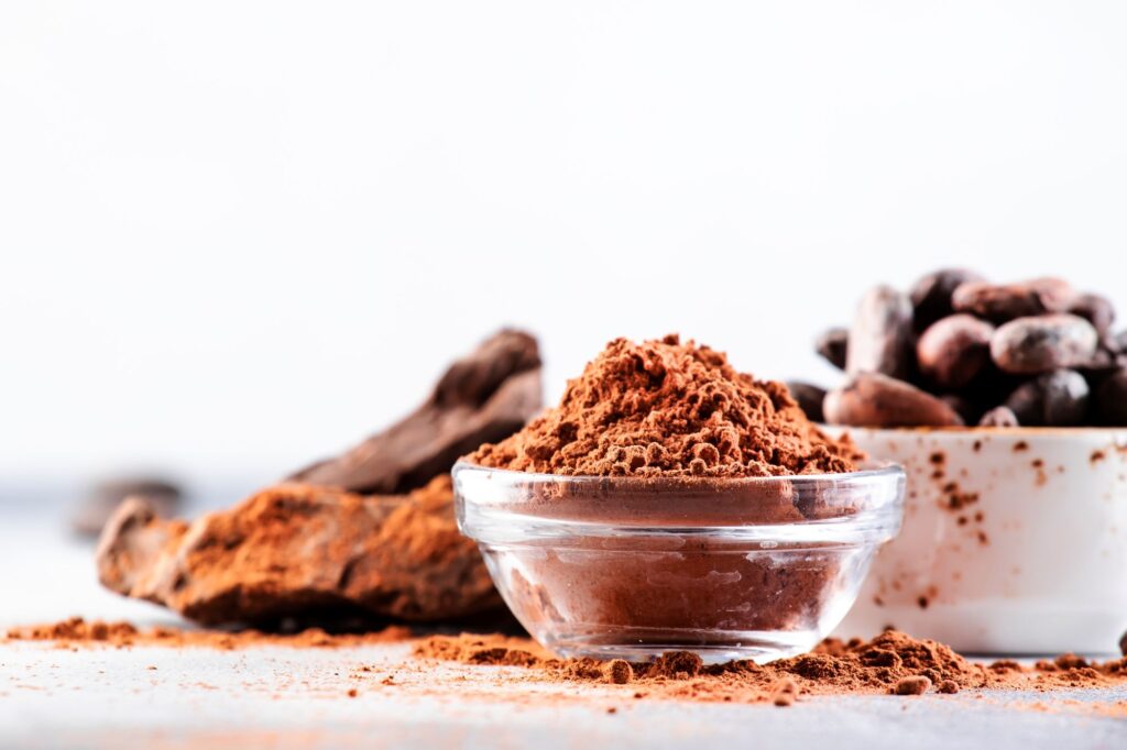 Bowl of natural cocoa powder and beans