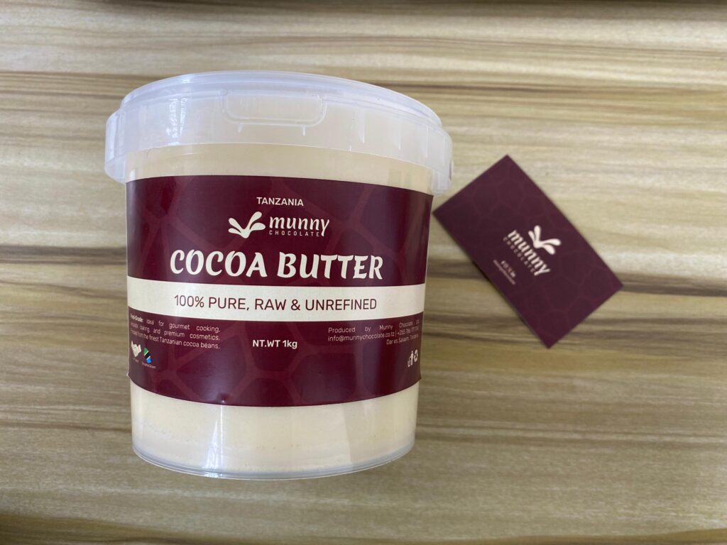 A 1 kilogram of Tanzania raw cocoa butter with a creamy, natural texture on a neutral background.