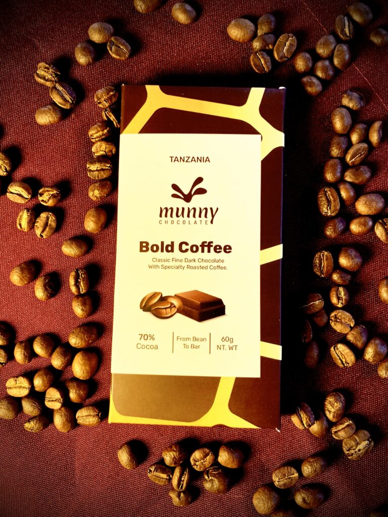 Bold Coffee 70% Tanzanian Dark Chocolate bar surrounded by roasted coffee beans