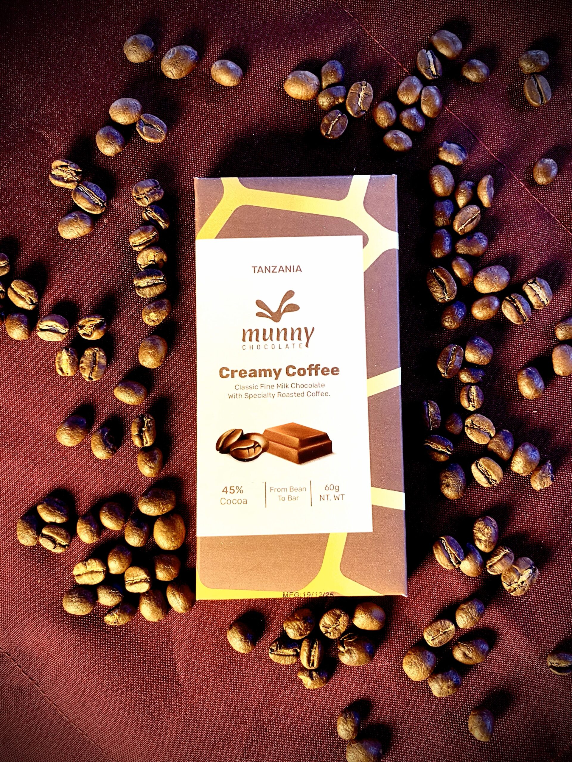 Creamy Coffee 45% Tanzanian Milk Chocolate bar surrounded by coffee beans